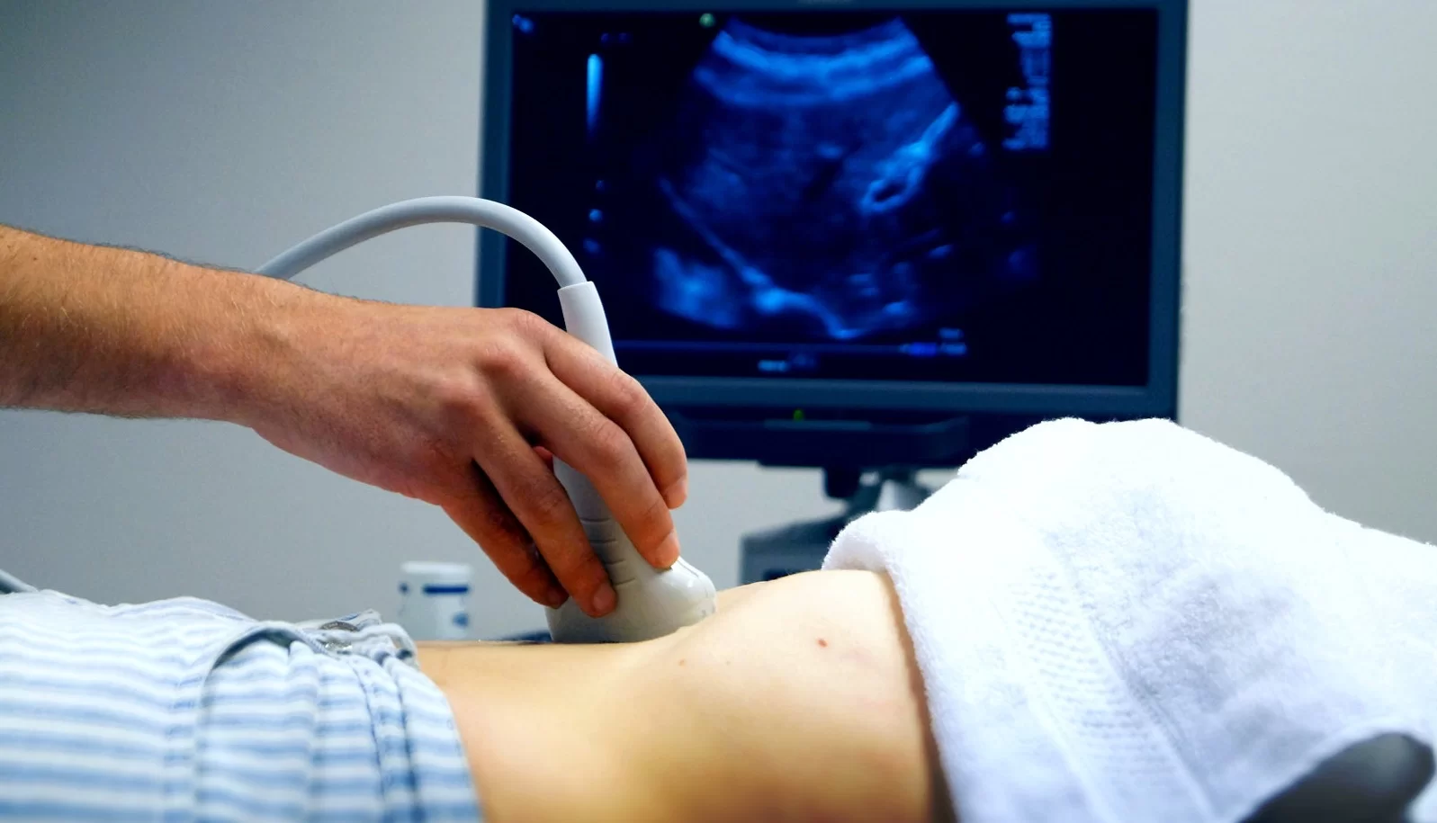 Врач проводит УЗИ-диагностику печени пациенту